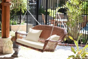 Honey Resin Wicker Porch Swing with Ivory Cushion